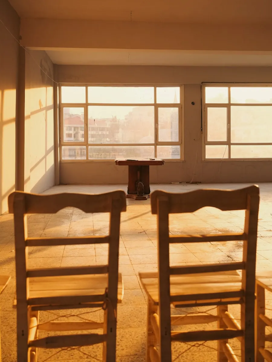 Dos sillas de madera vacías frente a una ventana