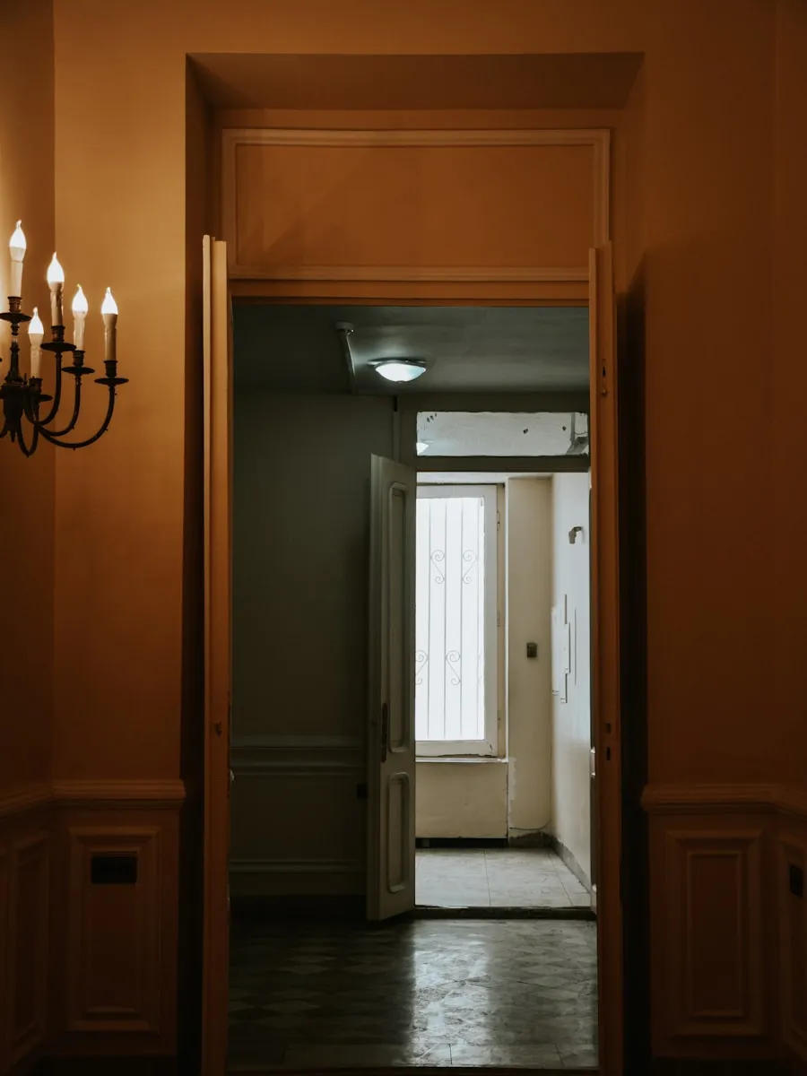 Un pasillo con una puerta abierta al fondo